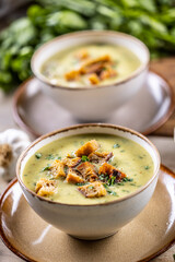 Garlic cream soup with bread croutons and flavored with copped celery leaves
