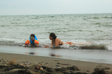 A girl and a boy lie on the shore of the Black Sea
