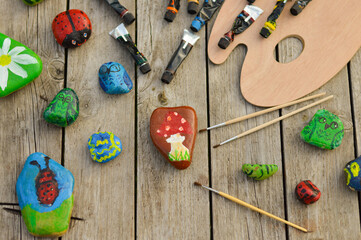 Flat stones painted with acrylic paints. Do it yourself. Souvenirs that children can make.