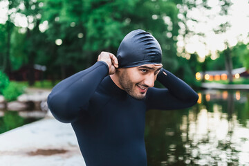 Smiling man putting on swimming cap