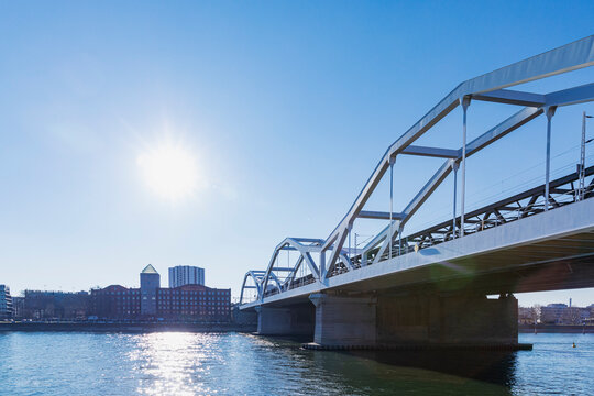 Germany, Baden-Wurttemberg, Mannheim, Sun shining over Konrad Adenauer Bridge stretching over Rhine River
