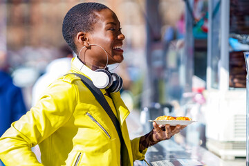 Smiling woman holding food plate at concession stand