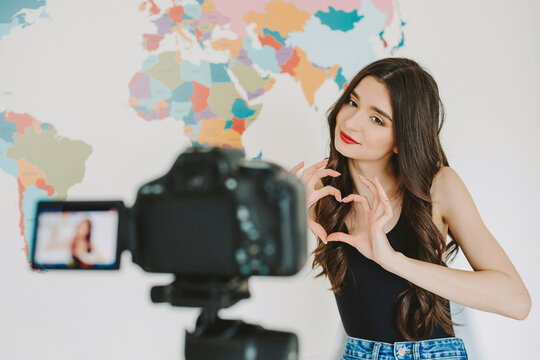 Young influencer making heart shape with hands in front of camera