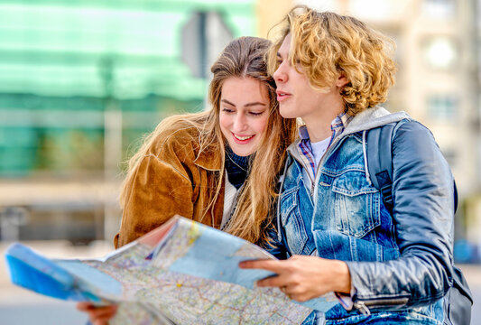Young man holding map by friend on vacation