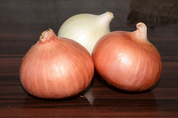 Yellow and white onions on dark wooden background