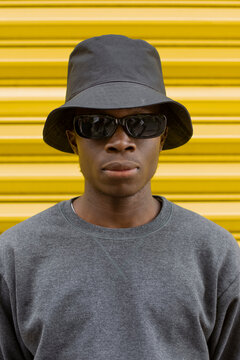 Man wearing bucket hat in front of yellow shutter
