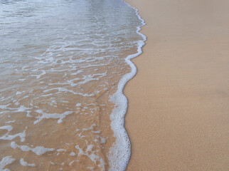 White wave splash on the sand beach for Nature background wallpaper, copy space