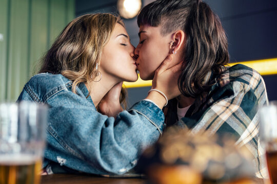 Young lesbian couple kissing each other at restaurant
