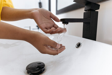 Woman washing her hands in bathroom sink