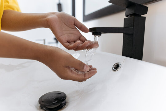 Woman washing her hands in bathroom sink - Powered by Adobe