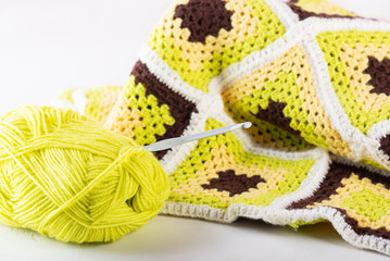 A ball of thread with knitting in the style of a patchwork.