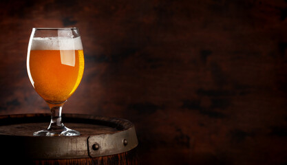 Beer glass on wooden barrel