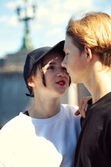 A young couple of teenagers are happy together and want love. First kiss. Girl in a cap