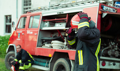 Firefighter with uniform and helmet stand in front of electric wire on a roof top