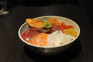 Delicious and healthy sashimi kaisendon set in a bowl with raw fish, urchin, seafood and rice in a restaurant in Japan