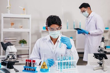 Two Male Scientists with Mask working in Lab while Checking Result of Blood Sample testing.