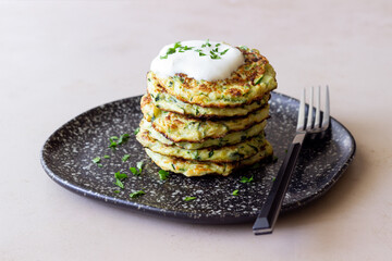 Zucchini fritters or pancakes with sour cream and herbs. Healthy eating. Vegetarian food.