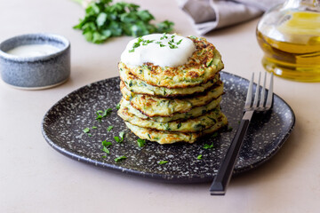 Zucchini fritters or pancakes with sour cream and herbs. Healthy eating. Vegetarian food.