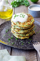 Zucchini fritters or pancakes with sour cream and herbs. Healthy eating. Vegetarian food.