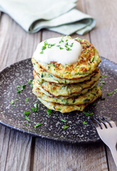 Zucchini fritters or pancakes with sour cream and herbs. Healthy eating. Vegetarian food.