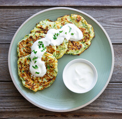 Zucchini fritters or pancakes with sour cream and herbs. Healthy eating. Vegetarian food.