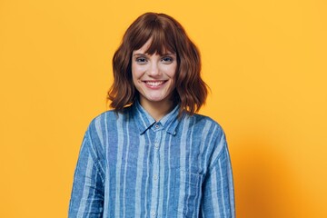 Fototapeta premium horizontal photo on a yellow background of a cute, happy woman in a blue shirt