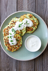 Zucchini fritters or pancakes with sour cream and herbs. Healthy eating. Vegetarian food.