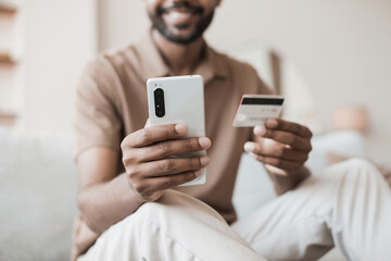 Man holding credit card and using smartphone at home, businessman shopping online, e-commerce, internet banking, spending money, working from home concept