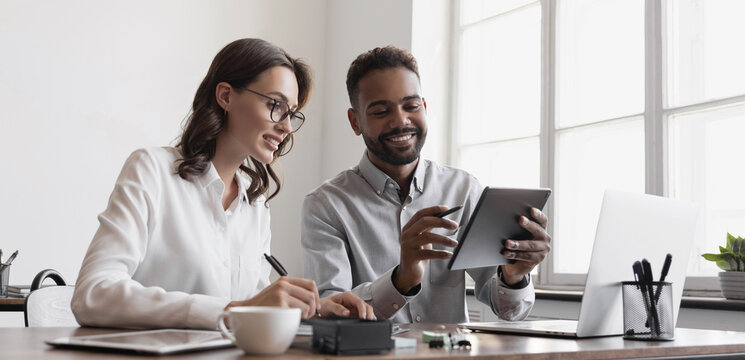 Coworkers working together in boardroom, brainstorming, discussing and analyzing business strategy. Young people professionals working in office, Colleagues using digital tablet in coworking.