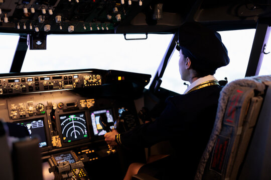 Copilot helping captain to fly airplane with cabin command and buttons on dashboard navigation. Piloting aircraft with radar compass, windscreen and control panel switch or lever.