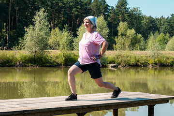 An aged woman performs fitness exercises and stretching in the fresh air. . Cardiac muscle training. Healthy lifestyle .