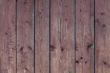 Brown vertical planks with knots and chipped away paint
