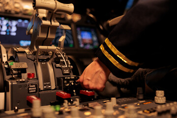 Female copilot pushing dashboard buttons in plane cockpit, preparing to takeoff with engine lever...
