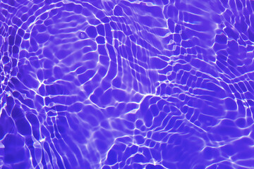 Defocus blurred transparent purple colored clear calm water surface texture with splash, bubble. Shining purple water ripple background. Surface of water in swimming pool. Tropical purple water color.