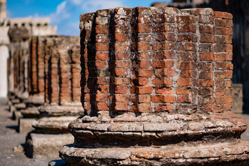 Historic row of columns built of red bricks by Roman people in comune of Pompei near Naples Italy....