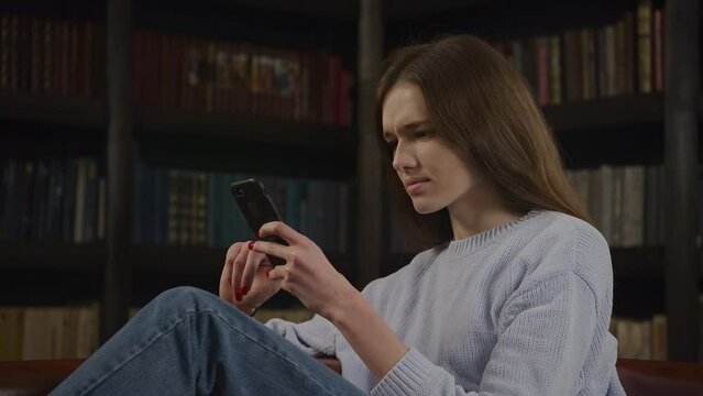 Caucasian woman browsing on her smart phone recieving bad news online