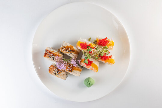 sushi on a plate with cheese and vasabi