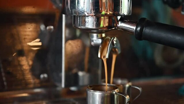 Grinding coffee bean with coffee maker pouring dark coffee