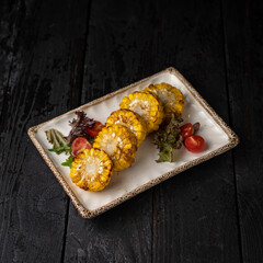 appetizing grilled vegetables on plates on a dark wooden table
