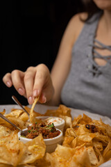 Nachos with sauces on plates on a wooden table
