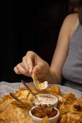Nachos with sauces on plates on a wooden table