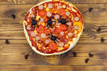 Halloween pizza with spiders on wooden table. Top view