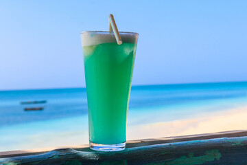 Glass of Blue Hawaii cocktail by the ocean