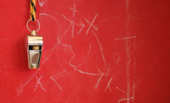 Whistle of soccer referee or trainer and soccer tactics scribble on red background. Great soccer event this year, large free copy space