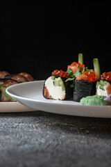 sushi rolls on white plate and black background