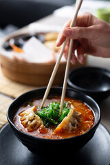 Japanese soup. The woman is eating the soup with chopsticks