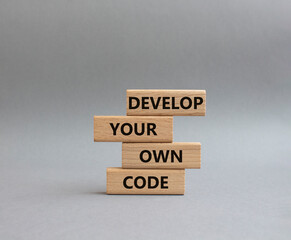 Develop your own code symbol. Concept words Develop your own code on wooden blocks. Beautiful grey background. Business and Develop your own code concept. Copy space.