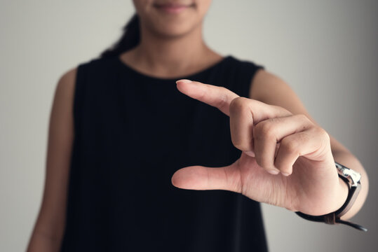 Asian woman hand gestures selecting something in copy space. Fingers gesture for composing ideas. Conceptual of technology, virtual space and innovation.