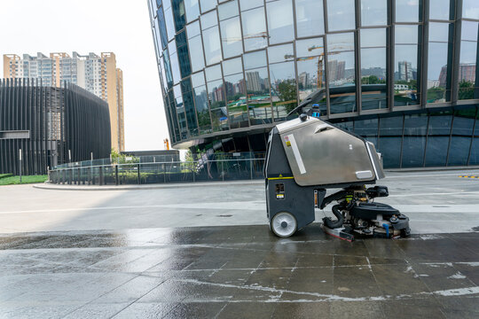 Chongqing, China-August,21 2022: automatic AI cleaner mopping floor outside of modern office building.