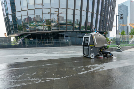 Chongqing, China-August,21 2022: automatic AI cleaner mopping floor outside of modern office building.